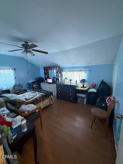 bedroom with ceiling fan, wood finished floors, and lofted ceiling