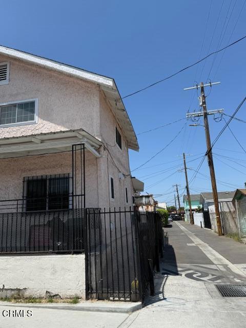 view of side of property featuring fence private yard and stucco siding