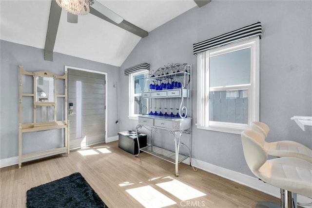 interior space featuring wood finished floors, baseboards, vaulted ceiling, and ceiling fan
