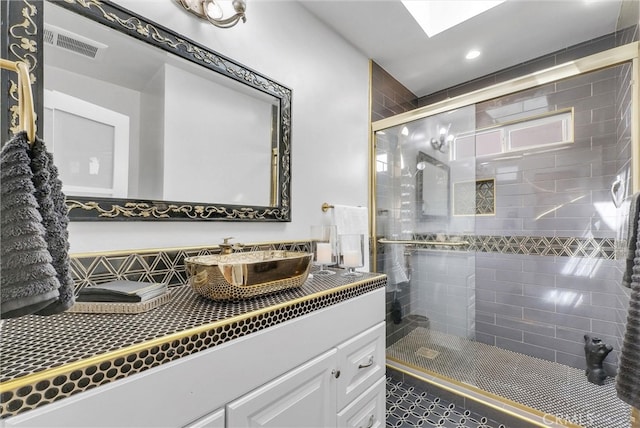 bathroom with a stall shower, vanity, visible vents, and recessed lighting