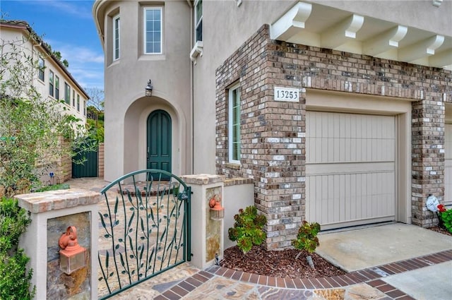 doorway to property with stucco siding and a gate