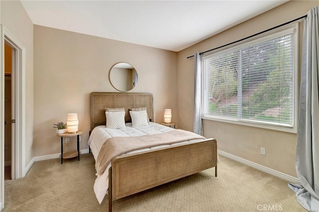 bedroom with light colored carpet and baseboards