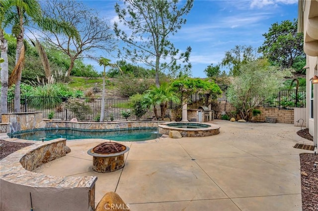 view of pool featuring a fenced backyard, an outdoor fire pit, a pool with connected hot tub, and a patio
