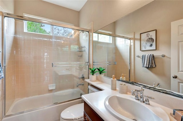 bathroom featuring toilet, vanity, and shower / bath combination with glass door
