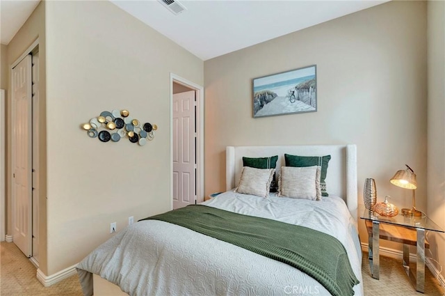 bedroom featuring visible vents, baseboards, and light carpet