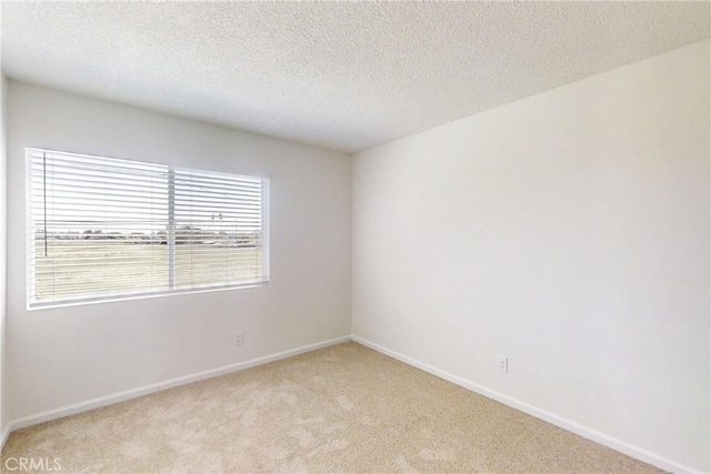 830 E Darlan St, Compton, CA 90220 - spare room with baseboards, a textured ceiling, and light colored carpet