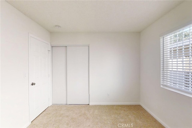 830 E Darlan St, Compton, CA 90220 - unfurnished bedroom with light colored carpet, baseboards, and a closet