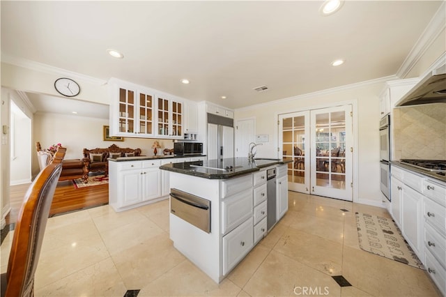 kitchen with a warming drawer, french doors, a sink, a center island with sink, and glass insert cabinets