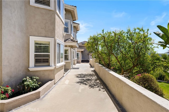 view of side of property featuring stucco siding and fence