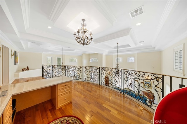 corridor with a chandelier, crown molding, coffered ceiling, light wood-type flooring, and an office area