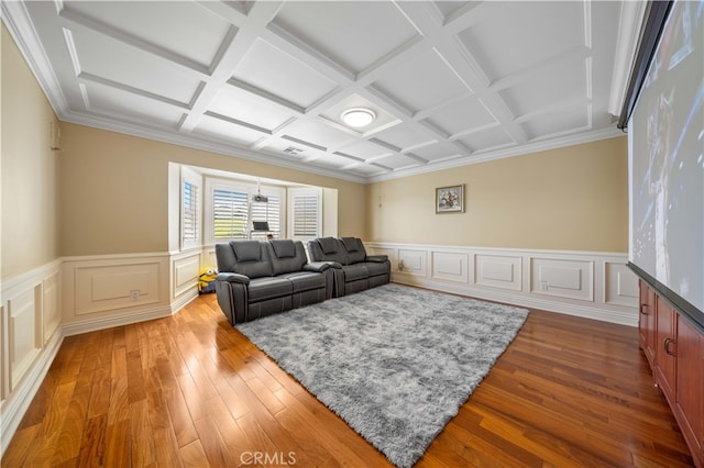 living area with coffered ceiling, wood-type flooring, a wainscoted wall, beamed ceiling, and ornamental molding