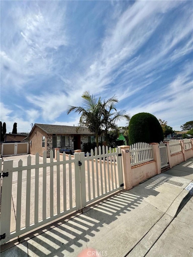 view of front of house with a fenced front yard, stone siding, and a gate