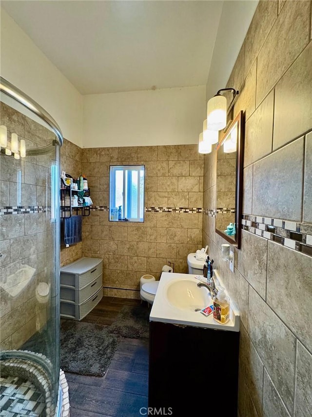 full bathroom with toilet, tile walls, hardwood / wood-style flooring, vanity, and a stall shower