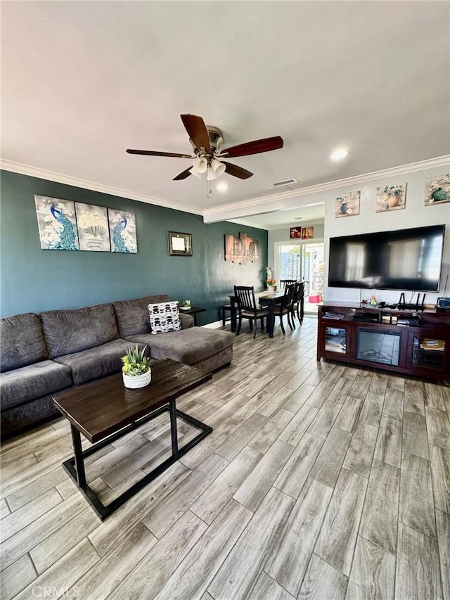 living room featuring crown molding, ceiling fan, and light wood-type flooring