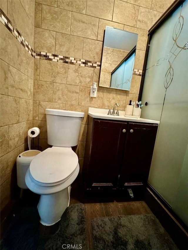 bathroom featuring vanity, tile walls, toilet, and wood finished floors