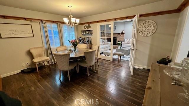 11406 Christy Ave, Sylmar, CA 91342 - dining space featuring baseboards, a notable chandelier, dark wood-style floors, and a fireplace