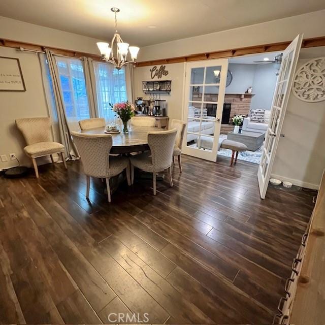 11406 Christy Ave, Sylmar, CA 91342 - dining room with a stone fireplace, a chandelier, and dark wood-style flooring