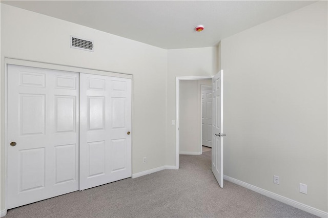unfurnished bedroom with visible vents, a closet, carpet flooring, and baseboards