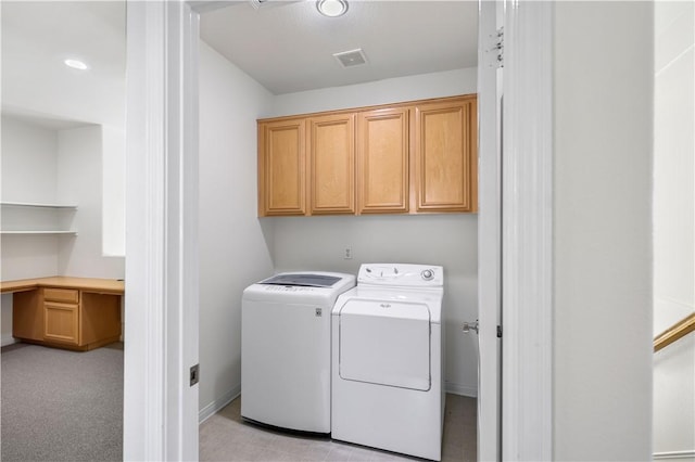 washroom featuring visible vents, washer and clothes dryer, and cabinet space