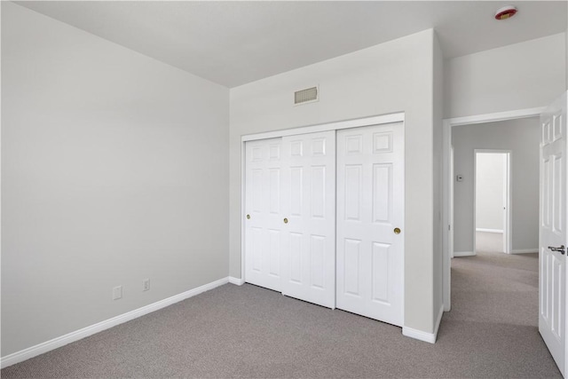 unfurnished bedroom with a closet, visible vents, carpet floors, and baseboards
