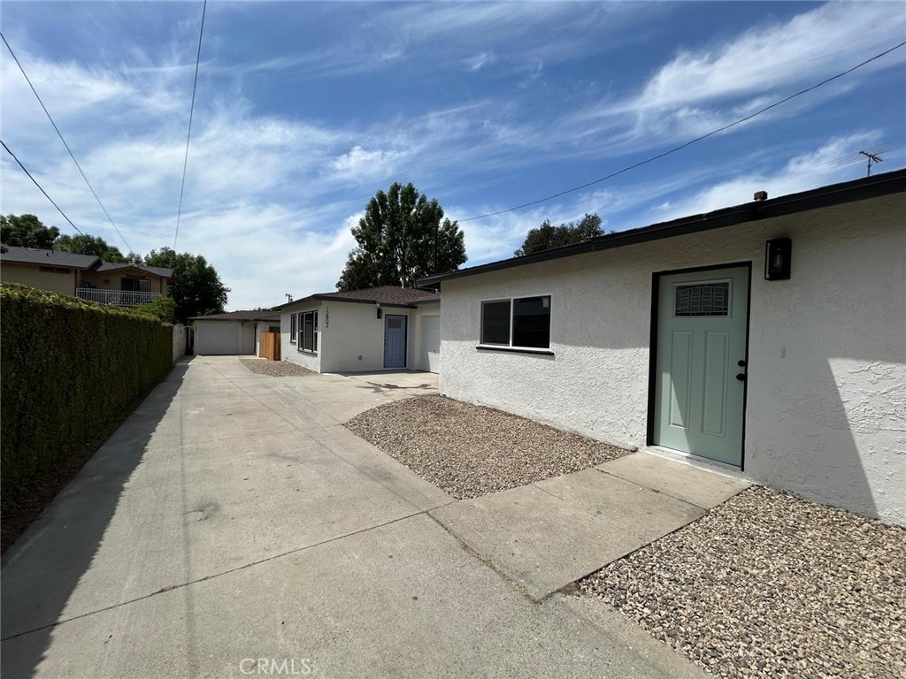 view of front of home featuring fence, a garage, and stucco siding