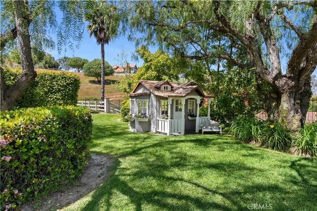 view of yard featuring fence and an outbuilding