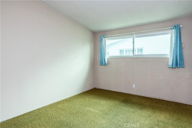 carpeted empty room featuring a textured ceiling