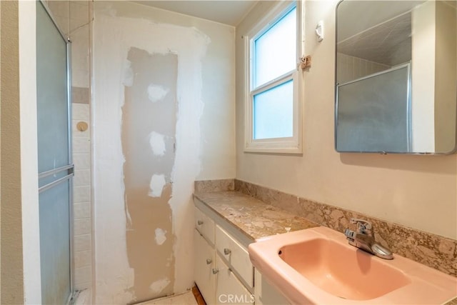 full bath featuring plenty of natural light, a shower with shower door, and vanity