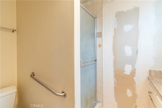 full bath featuring vanity, toilet, and a stall shower