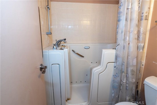 bathroom with a washtub, toilet, and a shower with shower curtain