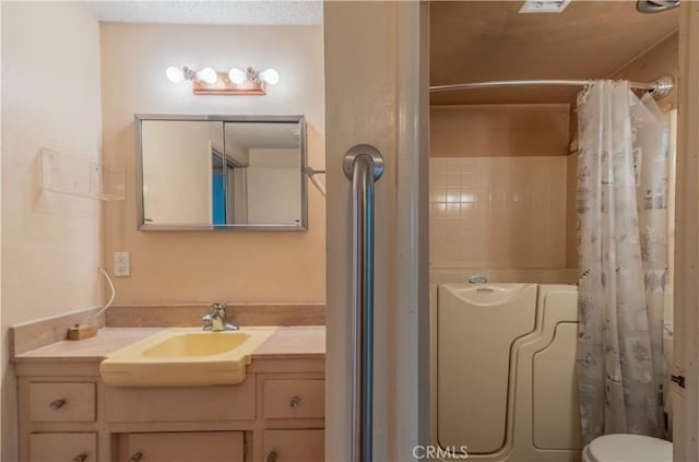bathroom featuring vanity, toilet, and curtained shower