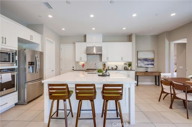 54 Rim Crst, Irvine, CA 92602 - kitchen with visible vents, a sink, appliances with stainless steel finishes, a kitchen breakfast bar, and decorative backsplash