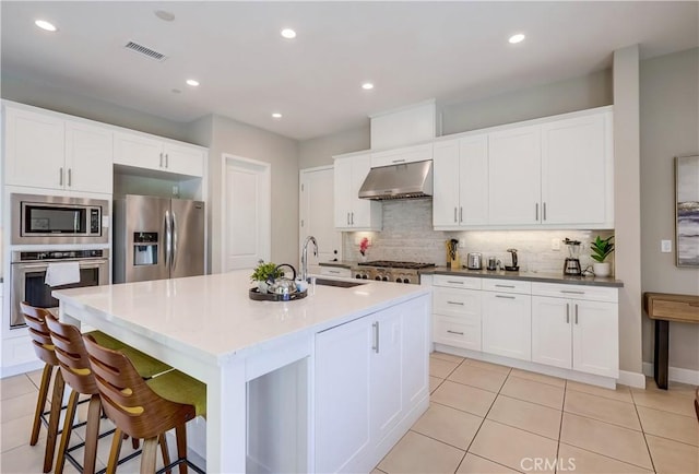 54 Rim Crst, Irvine, CA 92602 - kitchen with light tile patterned floors, appliances with stainless steel finishes, under cabinet range hood, a sink, and decorative backsplash