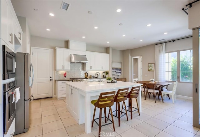 54 Rim Crst, Irvine, CA 92602 - kitchen with light tile patterned flooring, under cabinet range hood, visible vents, appliances with stainless steel finishes, and a sink