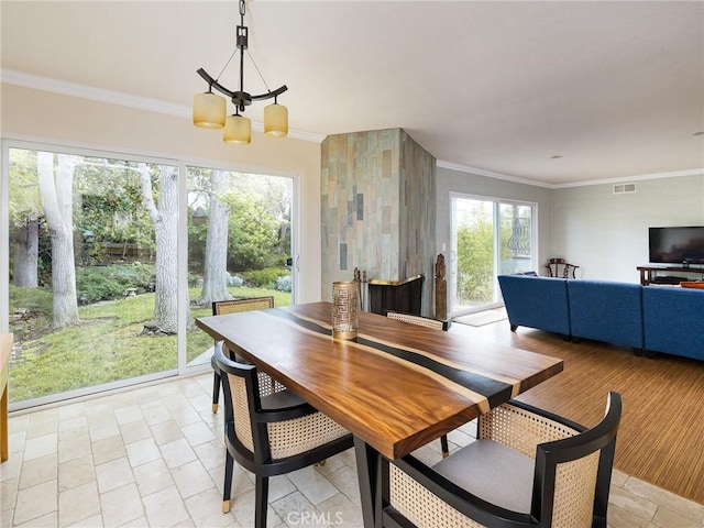 dining room with a chandelier, crown molding, visible vents, and plenty of natural light
