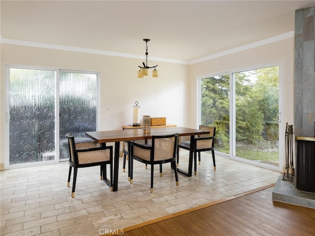 dining room featuring light wood-type flooring, ornamental molding, and plenty of natural light
