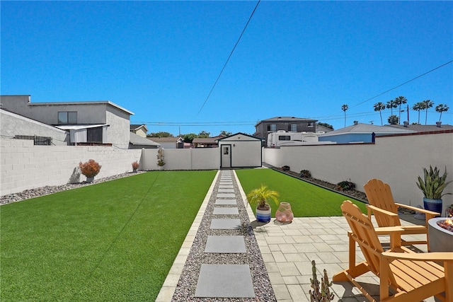 view of yard featuring a shed, a patio, a fenced backyard, and an outdoor structure