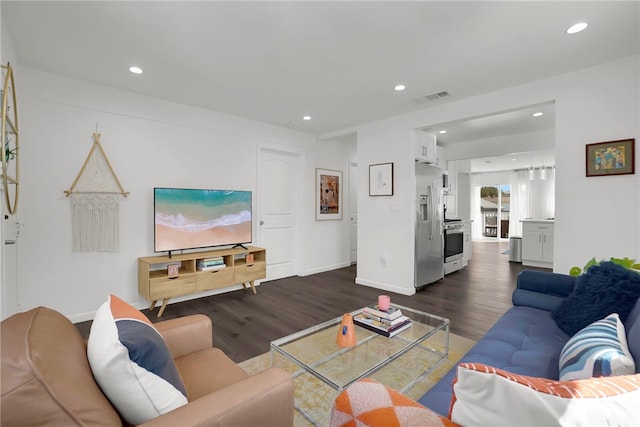 living area featuring recessed lighting, dark wood-type flooring, visible vents, and baseboards