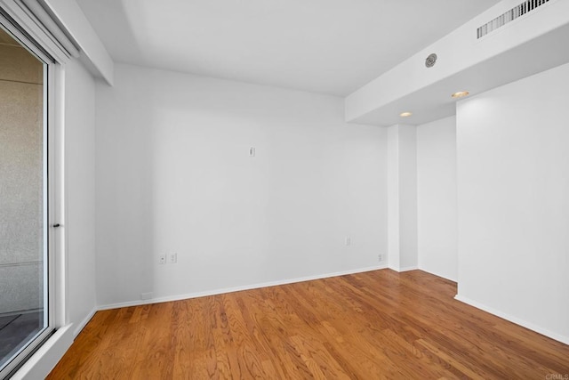 spare room featuring visible vents, wood finished floors, baseboards, and recessed lighting