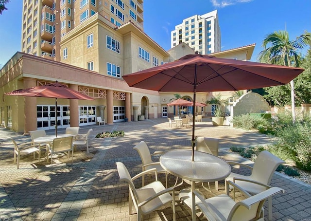 surrounding community featuring a patio and outdoor dining area