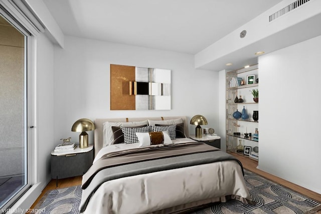 bedroom with visible vents and wood finished floors