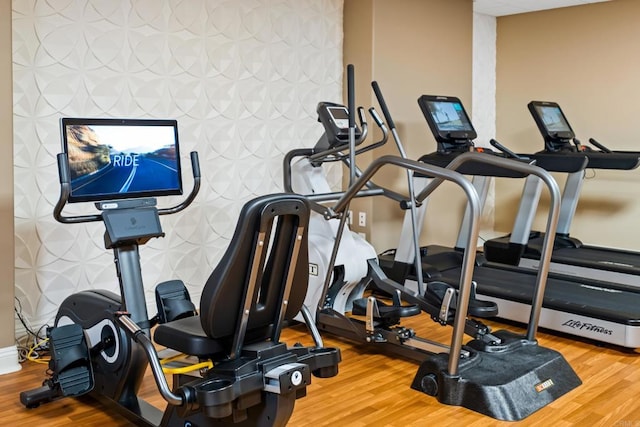 gym with baseboards and wood finished floors