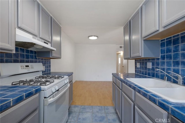 5055 Coldwater Canyon Ave Unit 105, Sherman Oaks, CA 91423 - kitchen featuring white gas range, under cabinet range hood, and gray cabinetry