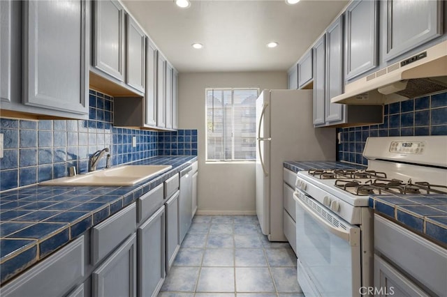 5055 Coldwater Canyon Ave Unit 105, Sherman Oaks, CA 91423 - kitchen with white range with gas cooktop, under cabinet range hood, tile counters, a sink, and recessed lighting
