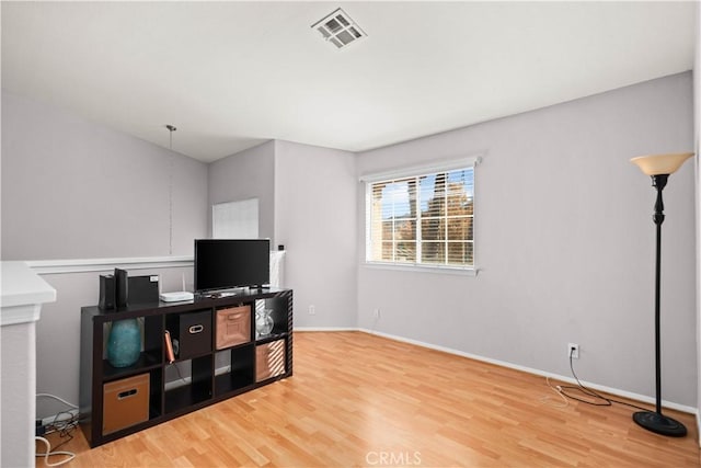 interior space with visible vents, baseboards, and wood finished floors