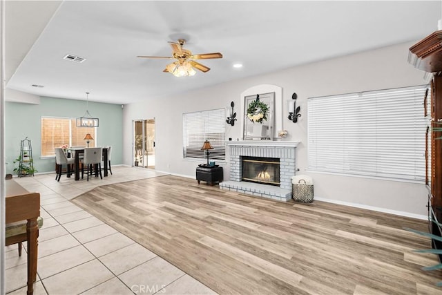 living area featuring baseboards, recessed lighting, a brick fireplace, visible vents, and ceiling fan
