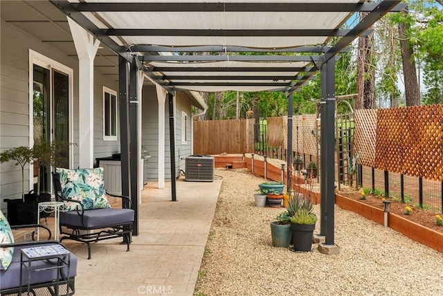 view of patio featuring central air condition unit, a fenced backyard, and a garden