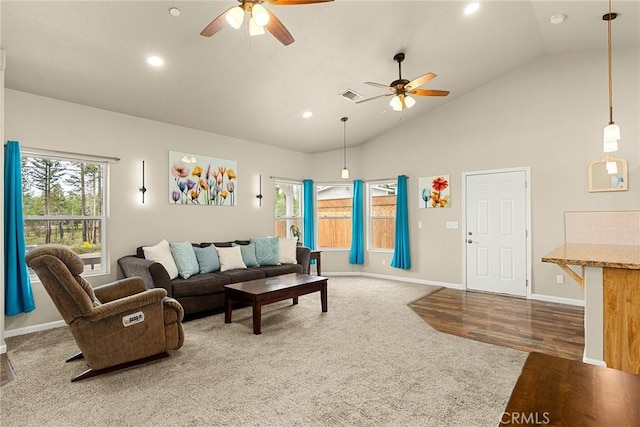 living room with plenty of natural light, visible vents, vaulted ceiling, and a ceiling fan
