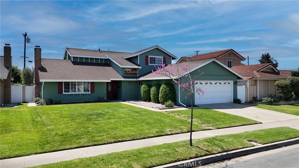 10448 Egret Ave, Fountain Valley, CA 92708 - traditional-style home featuring a front yard, driveway, fence, and an attached garage