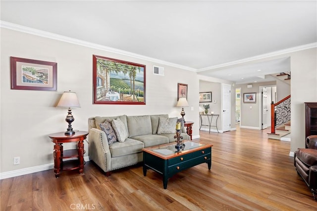 living area with visible vents, baseboards, stairway, and wood finished floors